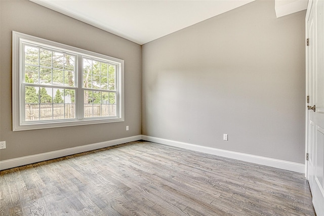 spare room with wood finished floors and baseboards