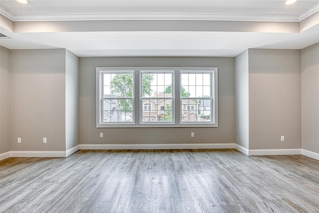 spare room with ornamental molding, wood finished floors, baseboards, a raised ceiling, and recessed lighting