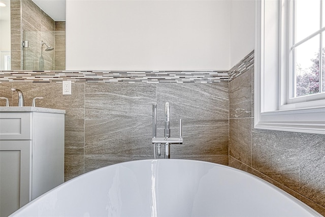 bathroom view of a freestanding tub, vanity, and a tile shower