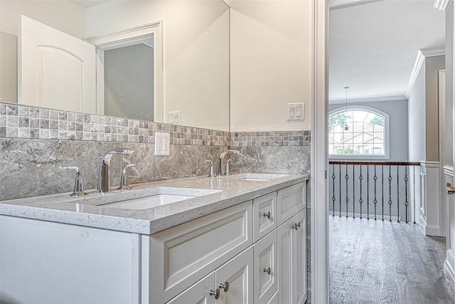bathroom with crown molding, wood finished floors, and double vanity