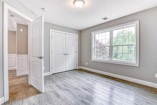 unfurnished bedroom with wood finished floors, a closet, and baseboards