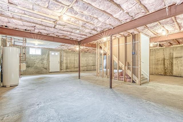 basement with gas water heater and stairway