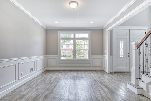 foyer entrance featuring stairs, wood finished floors, ornamental molding, wainscoting, and recessed lighting