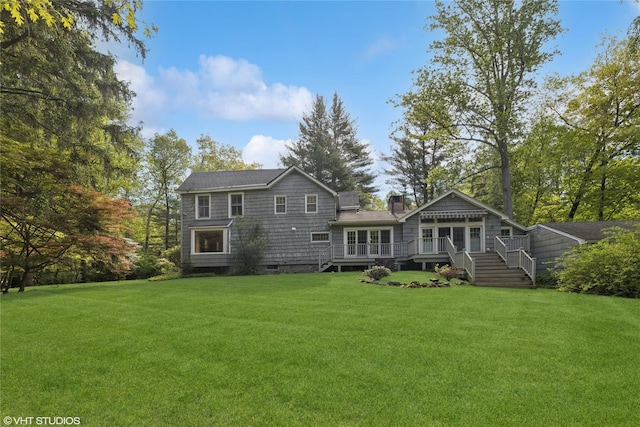 back of property featuring a deck, a yard, and a chimney