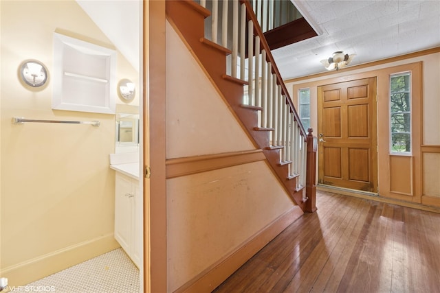 entryway featuring wood-type flooring, baseboards, and stairs