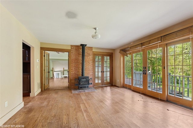 unfurnished sunroom with french doors and a wood stove