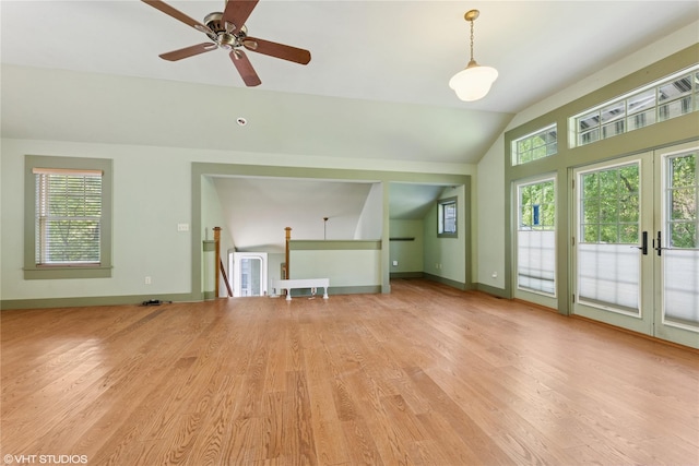 unfurnished living room featuring lofted ceiling, light wood-style flooring, ceiling fan, baseboards, and french doors