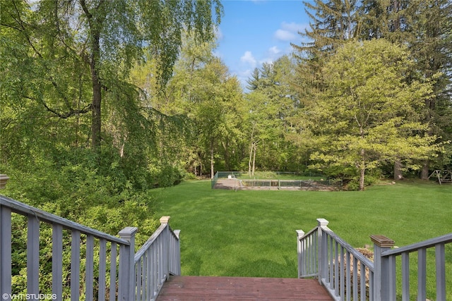view of grassy yard with a vegetable garden and a wooden deck