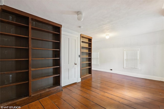 unfurnished room with hardwood / wood-style floors and baseboards