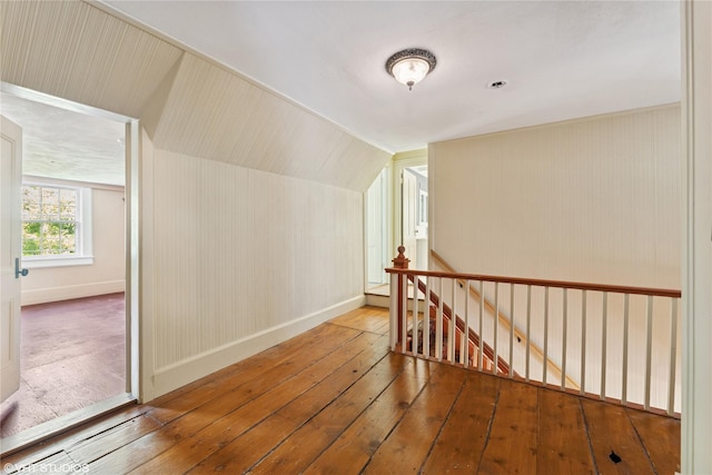 additional living space featuring hardwood / wood-style floors, baseboards, and vaulted ceiling