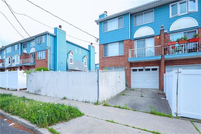 186 Monahan Ave, Staten Island, NY 10314 - view of front facade with brick siding, a garage, driveway, and fence
