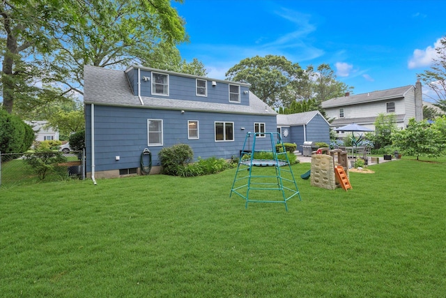 411 8th Ave, East Northport, NY 11731 - rear view of house with a shingled roof and a playground
