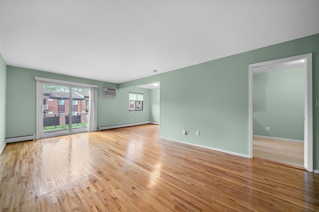 unfurnished living room featuring a baseboard radiator, wood finished floors, an AC wall unit, and baseboards