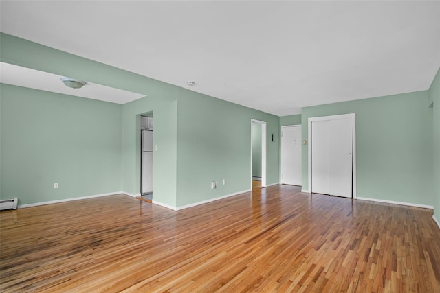 spare room featuring light wood-style flooring and baseboards