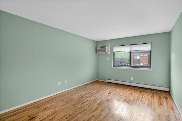 empty room featuring a baseboard radiator, hardwood / wood-style flooring, a wall unit AC, and baseboards