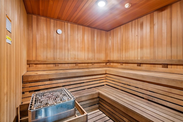 sauna with wood walls, wood ceiling, and recessed lighting
