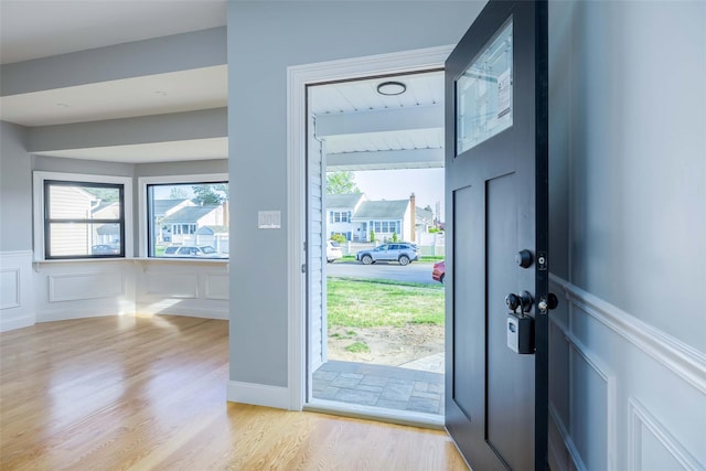 entryway featuring a decorative wall, a wainscoted wall, and light wood-style floors