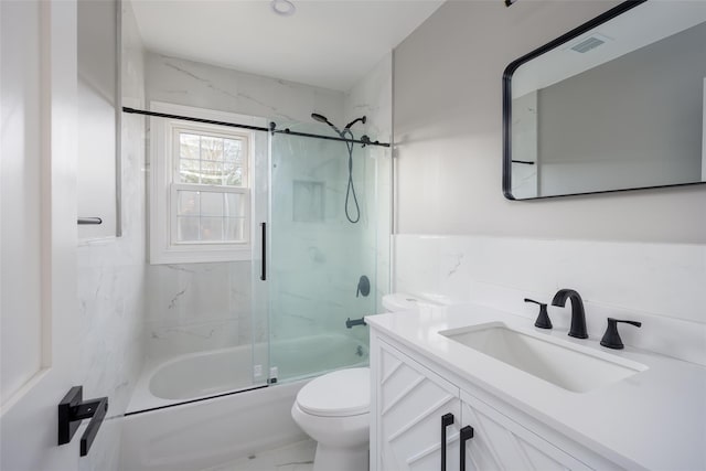 bathroom with toilet, bath / shower combo with glass door, and vanity