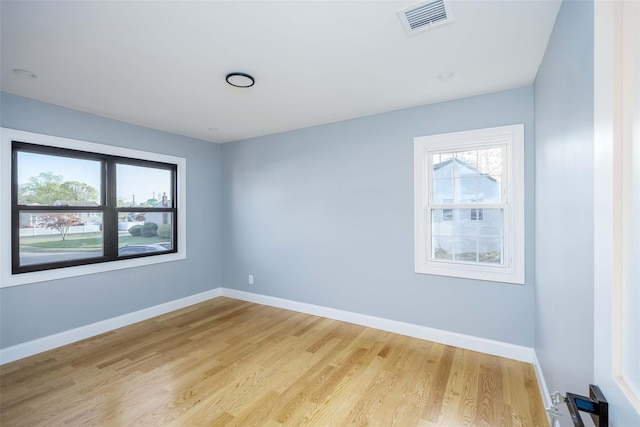 empty room with light wood-style floors and baseboards