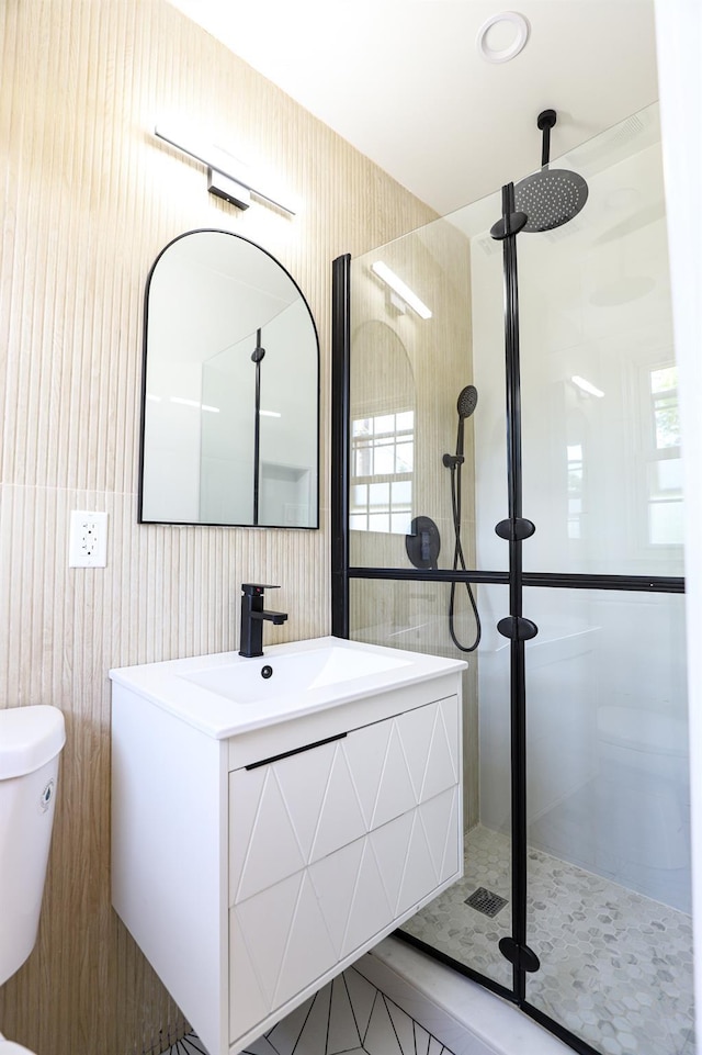 bathroom with a shower stall, toilet, vanity, and tile patterned flooring