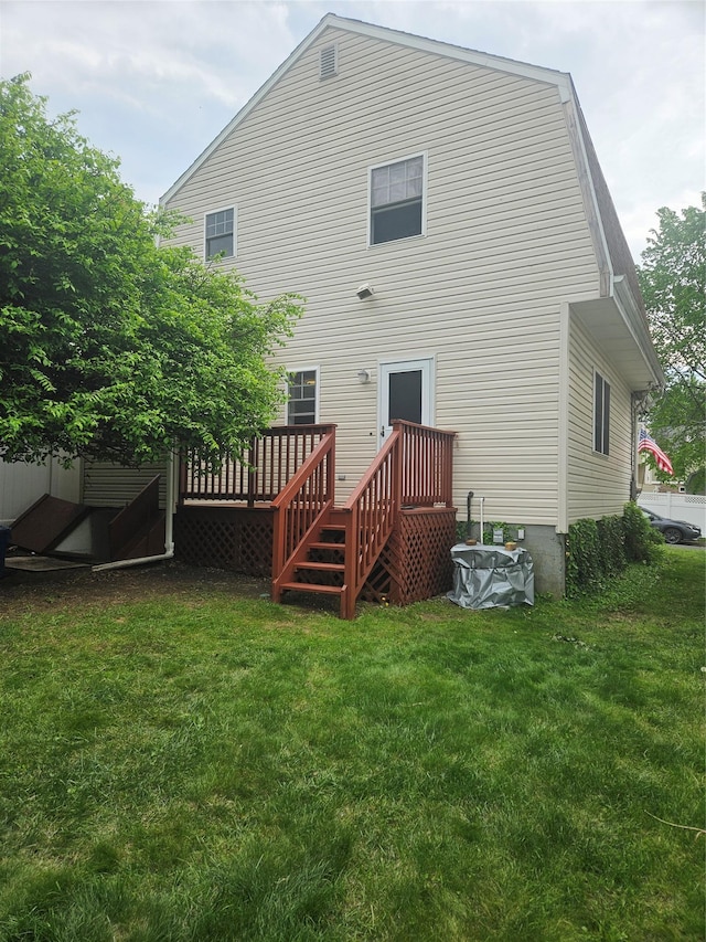 back of house with a lawn and a wooden deck