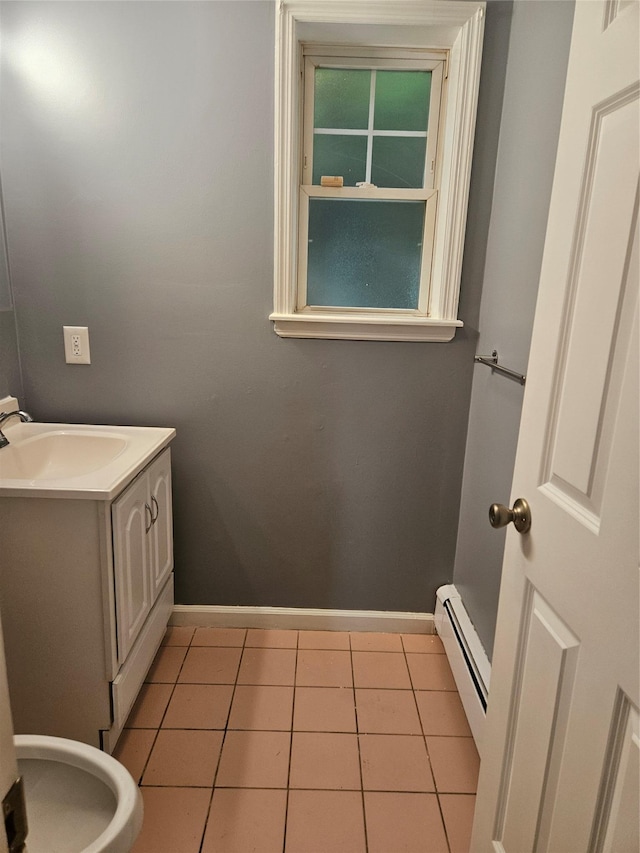 bathroom featuring baseboard heating, baseboards, tile patterned floors, and vanity