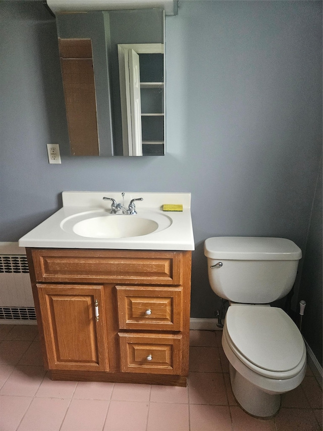 bathroom featuring vanity, toilet, radiator, tile patterned floors, and baseboards