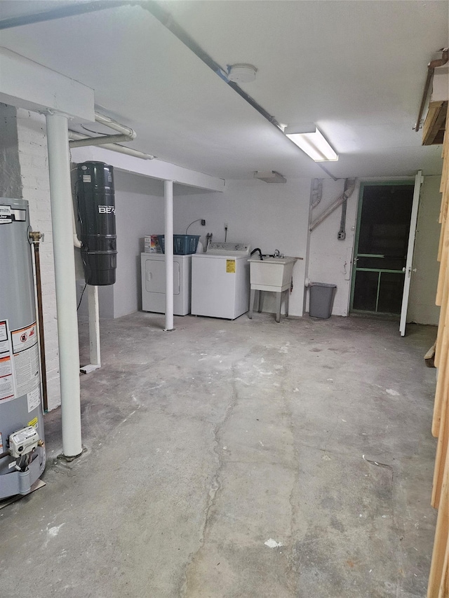 finished basement featuring gas water heater, washing machine and dryer, and a sink