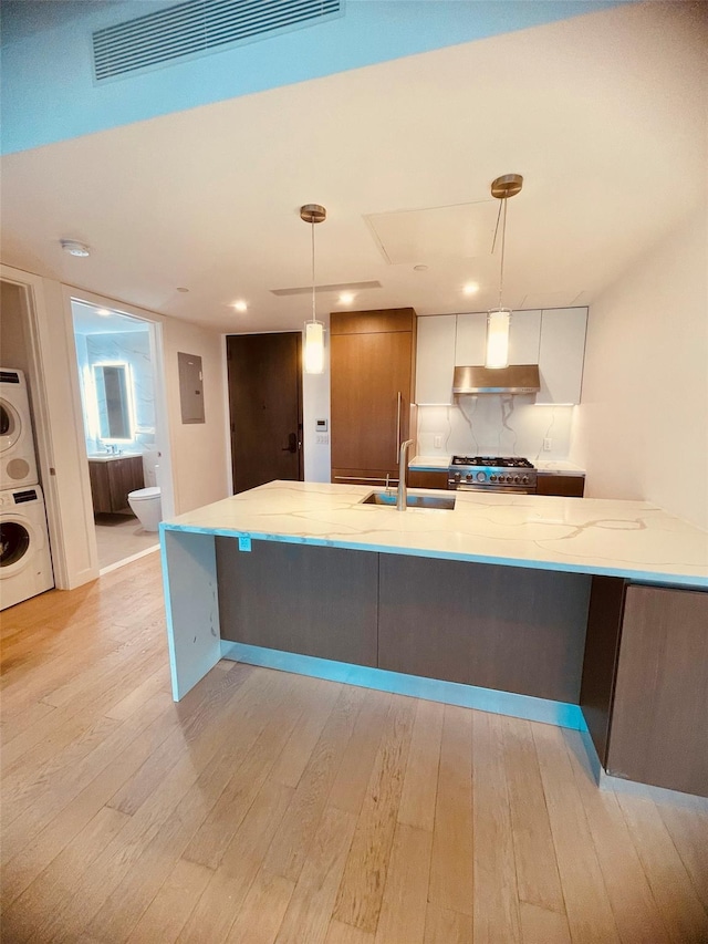 134-37 35th Ave Unit 8E, Flushing, NY 11354 - kitchen with stacked washer and clothes dryer, a sink, light wood finished floors, high end stainless steel range, and recessed lighting