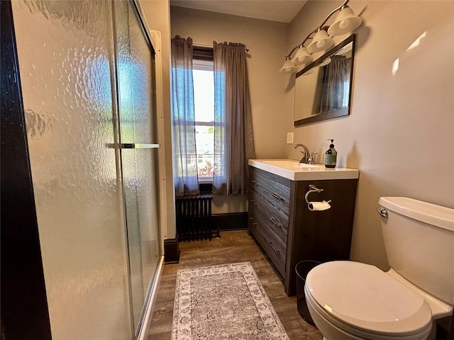 22 Herbert St, Beacon, NY 12508 - full bath with radiator heating unit, toilet, a stall shower, vanity, and wood finished floors