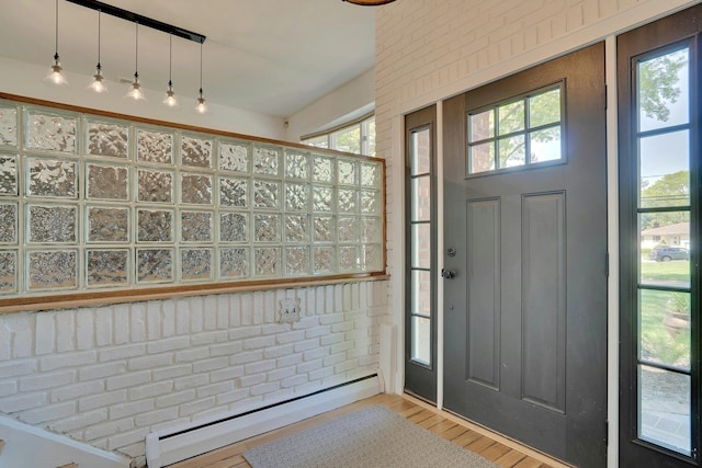 24 Harvard Ln, Commack, NY 11725 - foyer entrance with baseboard heating, plenty of natural light, wood finished floors, and brick wall