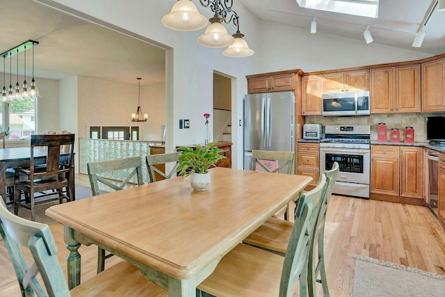 24 Harvard Ln, Commack, NY 11725 - kitchen with appliances with stainless steel finishes, light wood finished floors, a chandelier, lofted ceiling, and decorative backsplash