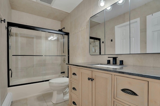 24 Harvard Ln, Commack, NY 11725 - bathroom featuring tile walls, shower / bath combination with glass door, toilet, tile patterned floors, and vanity