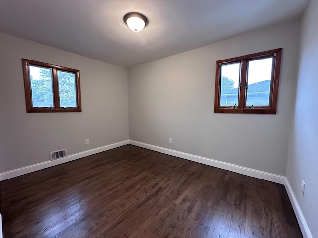 42 Blacker St, Brentwood, NY 11717 - empty room with healthy amount of natural light, dark wood finished floors, and baseboards