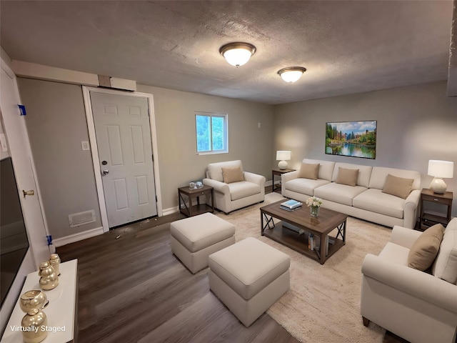 42 Blacker St, Brentwood, NY 11717 - living area with wood finished floors, baseboards, and a textured ceiling