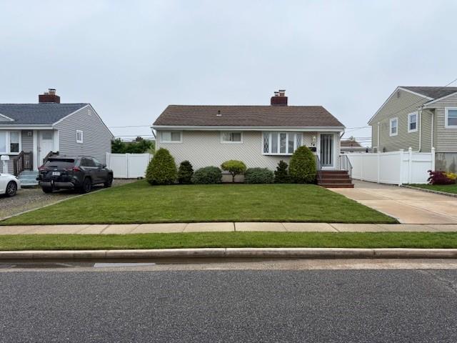 view of front of house featuring a chimney and driveway