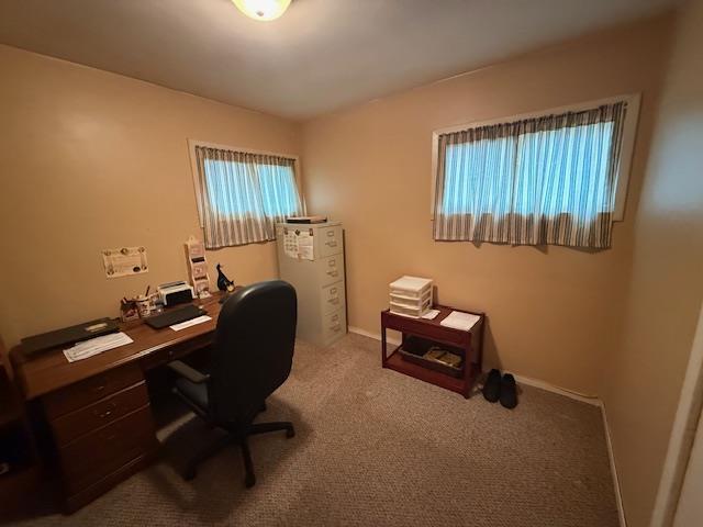 home office with carpet floors and baseboards