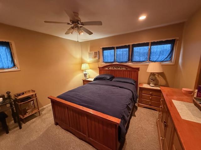 bedroom featuring light carpet and a ceiling fan