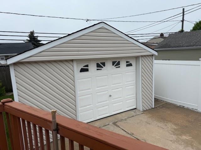 detached garage with fence and driveway