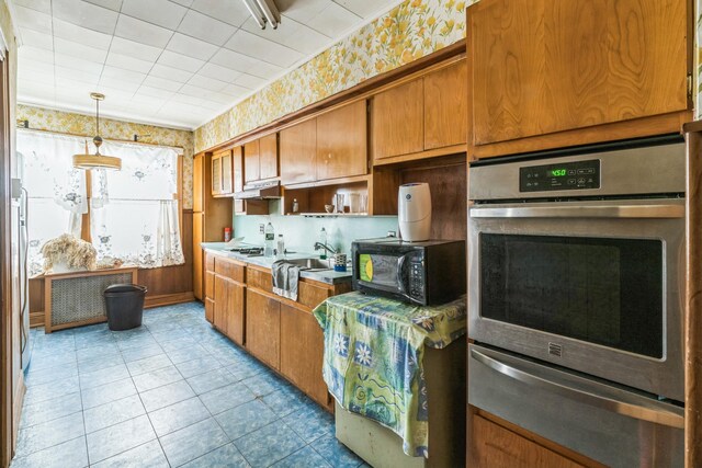 179-03 Selover Rd, Jamaica, NY 11434 - kitchen featuring oven, a warming drawer, black microwave, wallpapered walls, and brown cabinetry