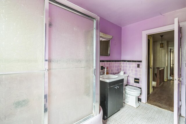 179-03 Selover Rd, Jamaica, NY 11434 - full bath featuring toilet, tile walls, vanity, a shower with door, and a wainscoted wall