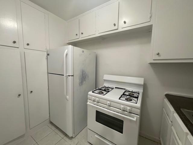 108-49 63rd Dr Unit 1K, Forest Hills, NY 11375 - kitchen with white appliances, white cabinets, and light tile patterned floors