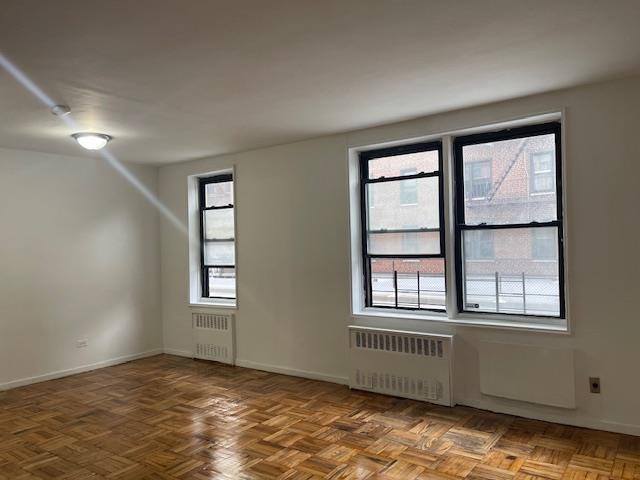 108-49 63rd Dr Unit 1K, Forest Hills, NY 11375 - unfurnished room featuring radiator heating unit