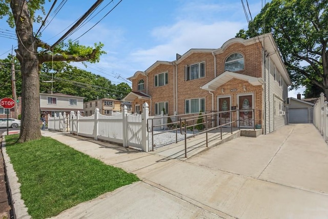23118 145th Ave, Springfield Gardens, NY 11413 - townhome / multi-family property featuring brick siding, a gate, an outdoor structure, and a garage