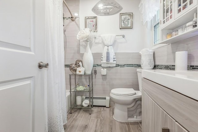 23118 145th Ave, Springfield Gardens, NY 11413 - full bathroom with baseboard heating, toilet, tile walls, vanity, and wood finished floors