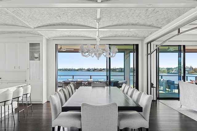 34 Westbridge Rd, Westhampton Beach, NY 11978 - dining space featuring a chandelier, dark wood-type flooring, a water view, and plenty of natural light