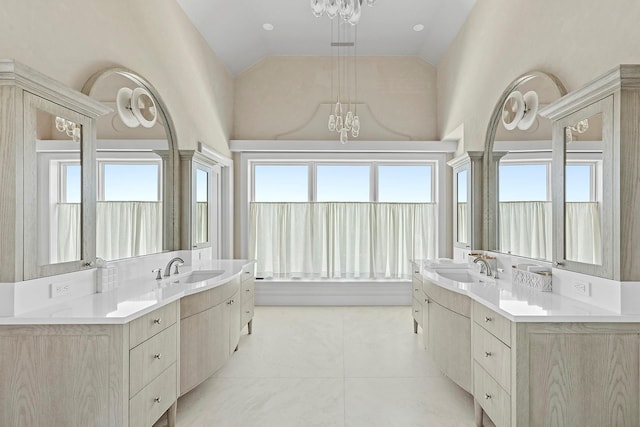 34 Westbridge Rd, Westhampton Beach, NY 11978 - bathroom featuring a chandelier, two vanities, tile patterned flooring, and high vaulted ceiling