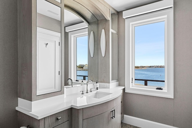34 Westbridge Rd, Westhampton Beach, NY 11978 - bathroom featuring a water view, vanity, and baseboards