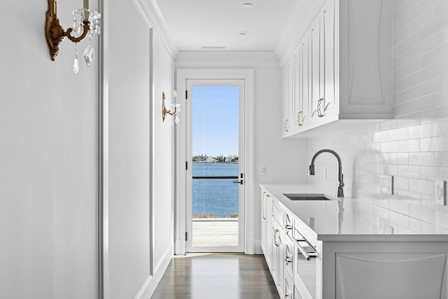 34 Westbridge Rd, Westhampton Beach, NY 11978 - bar featuring a sink, decorative backsplash, dark wood finished floors, and a water view