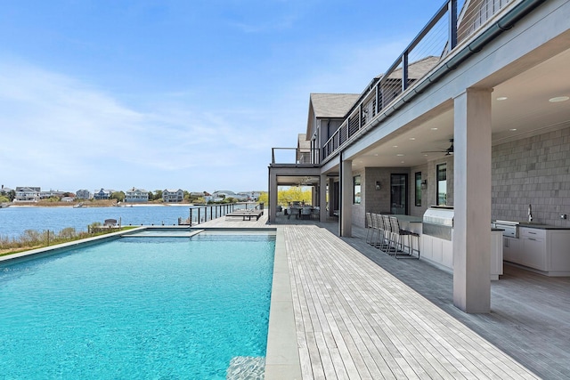 34 Westbridge Rd, Westhampton Beach, NY 11978 - outdoor pool featuring an outdoor kitchen, a water view, a ceiling fan, a patio area, and a bar